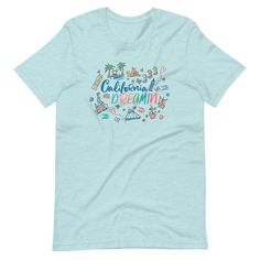 a light blue t - shirt with the words california dreaming written in colorful letters on it