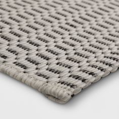 a close up view of the textured fabric on a rug in grey and white