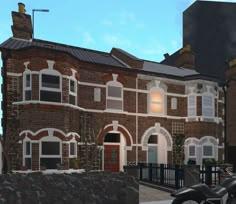 two motorcycles parked in front of a brick building with arched windows on the top floor