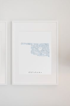 two framed pictures hanging on the wall next to each other, one with a blue and white flower design