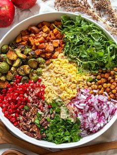 a large bowl filled with different types of vegetables and nuts on top of a table