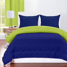 a bed with blue and green comforters in a room