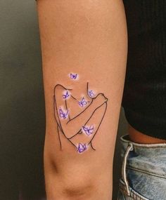 a woman's arm with purple butterflies on it and the word love written in black ink