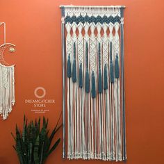 an orange wall with blue and white macrame hanging from it's side