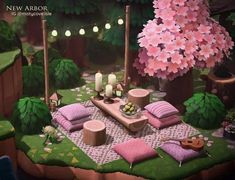 a table with pillows and candles on it in the middle of a lush green forest