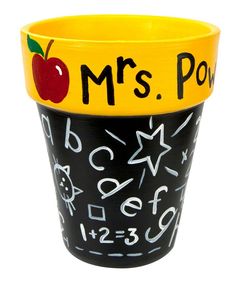 a black and yellow teacher's cup with an apple on the front, writing mrs poop