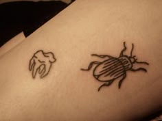 a tattoo on the leg of a person with a bug in it's arm