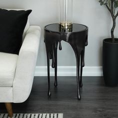 a white couch sitting next to a black and white table with a lamp on it