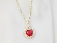 "This red heart necklace is made a 10mm ruby red cubic zirconia crystal heart, which is surrounded by sparkly clear cubic zirconia stones and dangles below a cubic zirconia bail on a lovely gold cable chain with a teardrop lobster clasp. This adjustable necklace can be worn from 16 to 19 inches and makes a lovely jewelry gift for her. Thank you for looking. NOTE: Gemsicles' gold-filled, rose/gold-plated, antiqued, matte, silver and rhodium jewelry is cadmium-free, lead-free and nickel-free. Also Cubic Zirconia Heart Necklace With Gemstone For Valentine's Day, Heart Necklace With Cubic Zirconia For Valentine's Day, Heart-shaped Cubic Zirconia Jewelry For Valentine's Day, Valentine's Day Heart Necklace With Cubic Zirconia Gemstone, Cubic Zirconia Heart Necklace With Gemstone, Red Heart Cut Necklace For Formal Occasions, Red Cubic Zirconia Heart Pendant Necklace, Red Heart-shaped Cubic Zirconia Necklace, Cubic Zirconia Heart Pendant Necklace For Jewelry Making