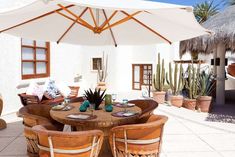 an outdoor dining area with table and chairs