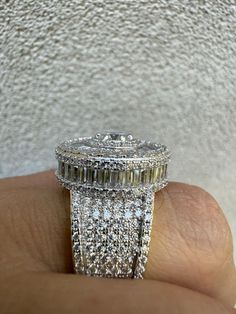 Gorgeous men's moissanite ring. One of the largest most iced out rings we made!
LARGE round classic ring with stones on all sides. Fully 3D 
Baguette stones on the sides and surrounding the large 1ct center stone!
 
8.1ct VVS D color excellent cut moissanite stones (4.45ct round stones & 3.65ct baguette) Large 1ct center stone!
PASSES DIAMOND TESTER!!! ANY PEN OR LIGHT TRANSMISSION DIAMOND TESTER 
(Will show up as moissanite and not diamond on lab assays however)
 
SOLID 925 sterling silver.
14k gold vermeil - gold bonded to solid silver underneath
Stamped 925
 
Will never tarnish or turn your hand green!
Moissanite on all sides...nice 3D effect of micropave stones
Look exactly like real diamonds!
 
Ring is 21-23 grams depending on Iced Out Rings, Green Moissanite, 10k Gold Chain, Red Stone Ring, Diamond Tester, Colored Engagement Rings, Gold Bond, Moissanite Earrings, Black Onyx Ring