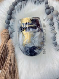 a white and black marbled glass with tassels on it's side