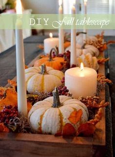 a table with candles and pumpkins on it