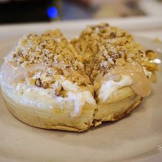 a pastry with icing and nuts on a plate