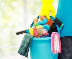 a person holding a bucket full of cleaning supplies