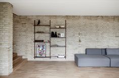 a living room filled with furniture and brick walls