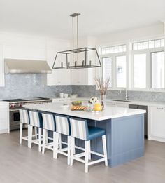 a large kitchen island with blue and white chairs