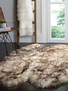 an area rug is shown in front of a chair and table with a plant on it