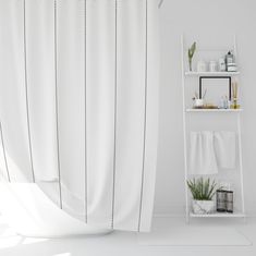 a white bathroom with a shower curtain and shelves