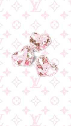 three pink hearts on a white background with louis vuitton symbols in the background