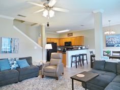 a living room filled with furniture next to a kitchen