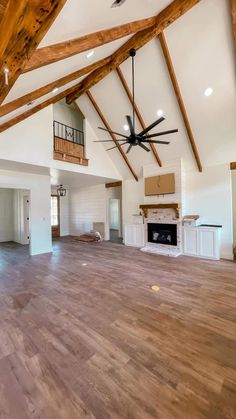 an empty living room with wood floors and exposed beams on the ceiling is seen in this image