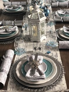 the table is set with blue and white plates, silverware, and napkins