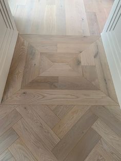 an empty room with wooden floors and white doors on one side, looking down at the floor