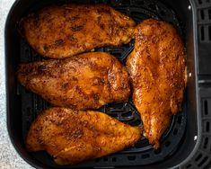 three pieces of chicken sitting in an air fryer