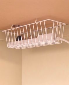 a white wire basket hanging from the ceiling