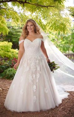 a woman in a wedding dress standing under a tree