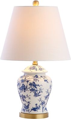 a blue and white vase with a gold base underneath a lampshade on a white background