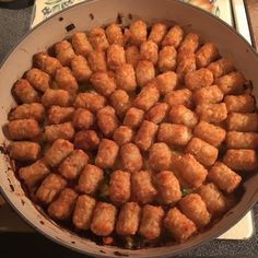 a pan filled with tater tots sitting on top of a counter