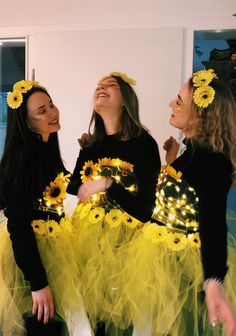 three girls dressed up in yellow tutus and sunflowers