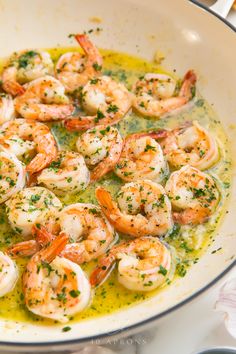 a pan filled with shrimp and sauce on top of a table