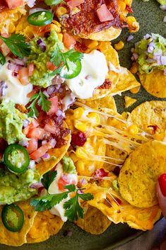 a plate full of nachos and chips with guacamole