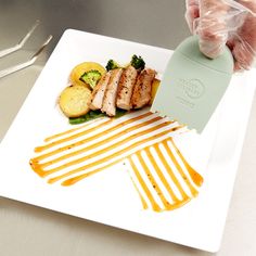 a plate with some food on top of it and a person holding a knife in front of it