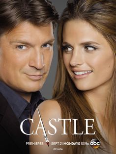 a man and woman standing next to each other in front of a poster for castle