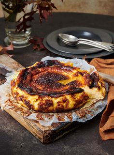 a table topped with a pizza covered in cheese and sauce next to a knife and fork