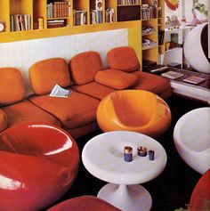 a living room filled with lots of furniture and bookshelves covered in yellow bookcases