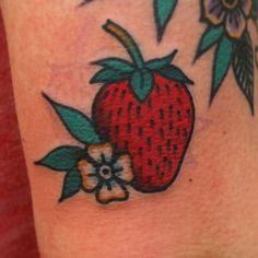 a strawberry and flower tattoo on the arm