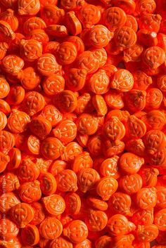 orange candies with carved faces on them are shown in this close up photo from above