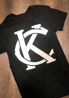 Rally Kansas City Monogram Black Short Sleeve Fashion T Shirt Summer Streetwear T-shirt With Monogram Print, Casual Black T-shirt With Monogram Print, Black Cotton T-shirt With Letter Print, Cotton T-shirt With Black Letter Print, White Monogram Print Streetwear Top, White Monogram Print Top For Streetwear, Short Sleeve Monogram Print T-shirt For Streetwear, Streetwear Monogram Print Short Sleeve T-shirt, Monogram Print Short Sleeve T-shirt For Streetwear