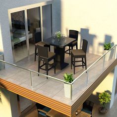 a balcony with chairs, table and potted plant on the top floor next to sliding glass doors