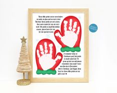 a christmas card with two handprints on it next to a small pine tree