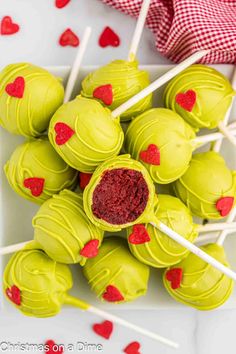 green cake pops with red hearts on them and candy sticks in the middle for valentine's day