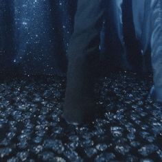 a person standing in the middle of a room with black and white floor tiles on it