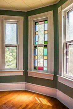 three stained glass windows in a green room with wood floors and hard wood flooring