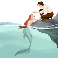 a man kneeling down next to a mermaid in the water