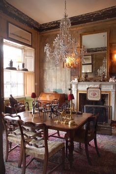 a dining room table with chairs and a chandelier hanging from it's ceiling